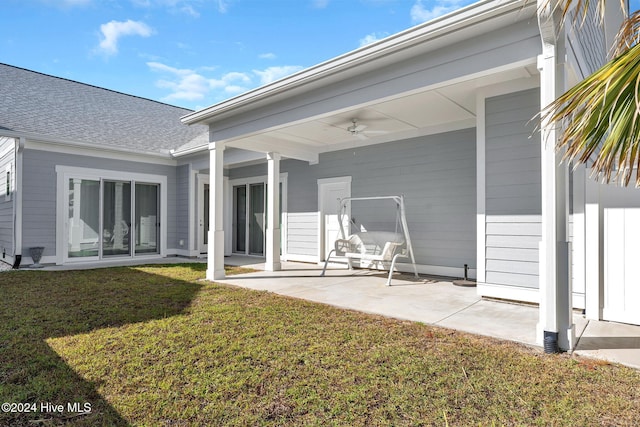 back of house featuring a lawn, ceiling fan, and a patio