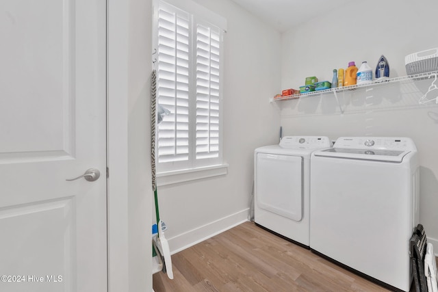 clothes washing area featuring light wood-type flooring and separate washer and dryer