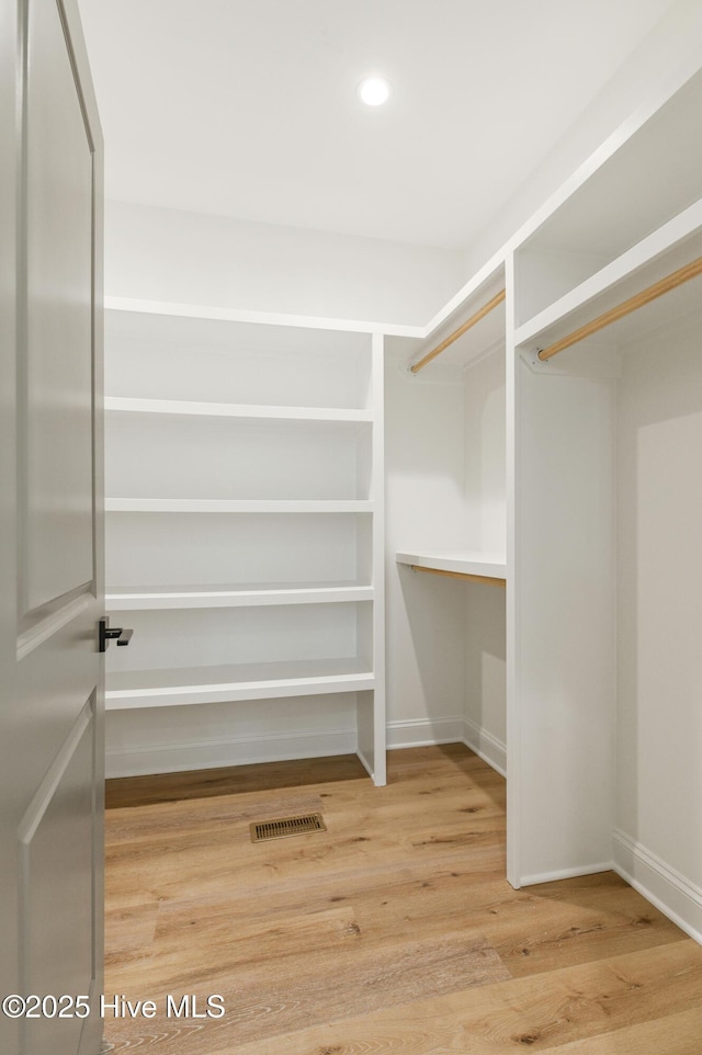 spacious closet with hardwood / wood-style flooring