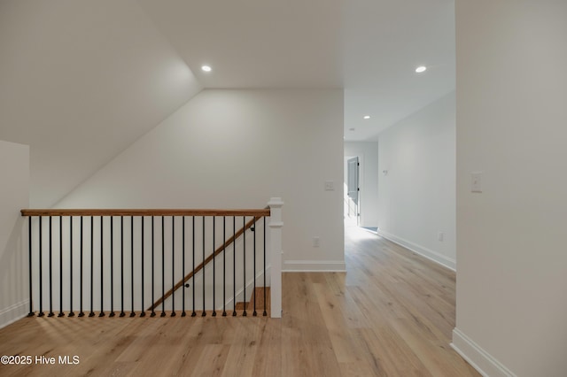 hallway featuring light wood-type flooring and lofted ceiling