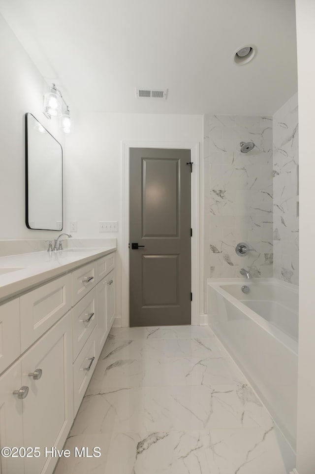 bathroom featuring vanity and tiled shower / bath