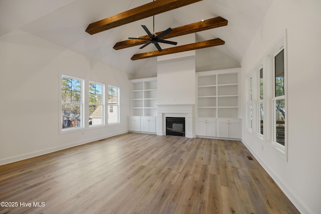 unfurnished living room with ceiling fan, light wood-type flooring, high vaulted ceiling, beam ceiling, and built in shelves