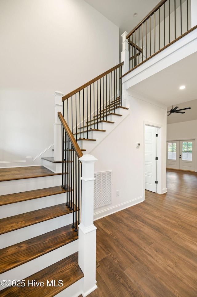 staircase with ceiling fan and hardwood / wood-style floors