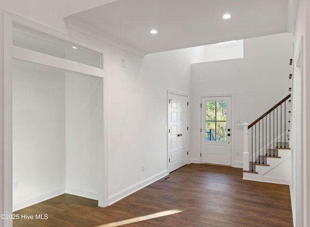 foyer featuring dark wood-type flooring and crown molding