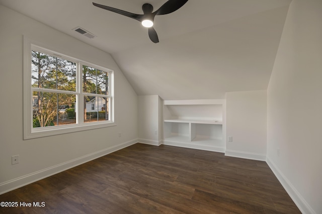 additional living space with ceiling fan, built in shelves, dark hardwood / wood-style floors, and lofted ceiling