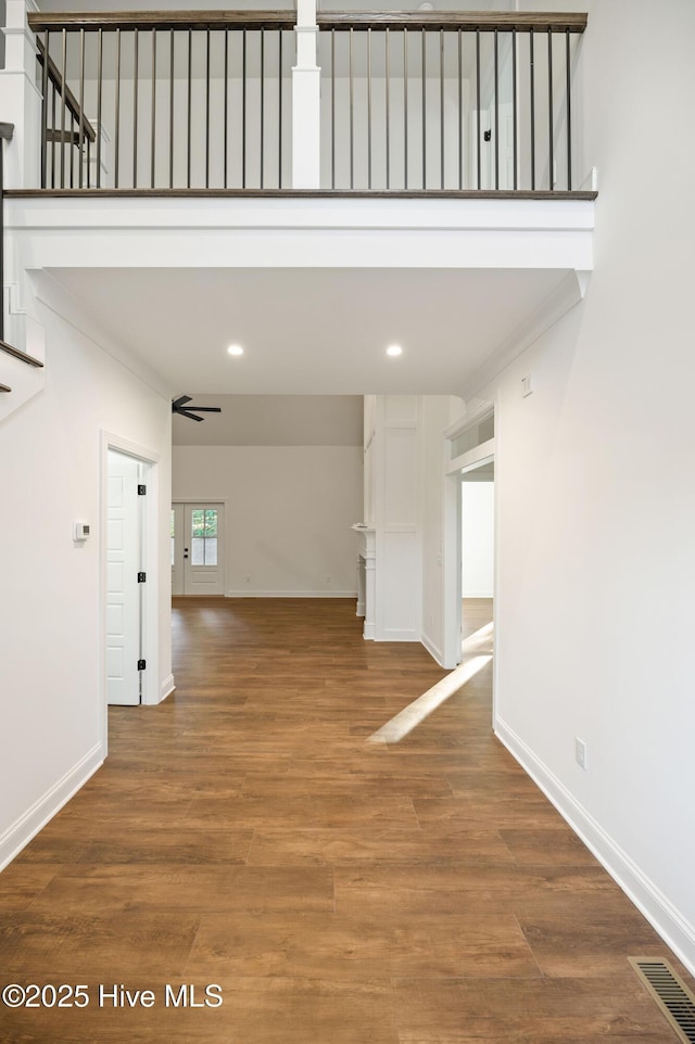 hallway with wood-type flooring and crown molding