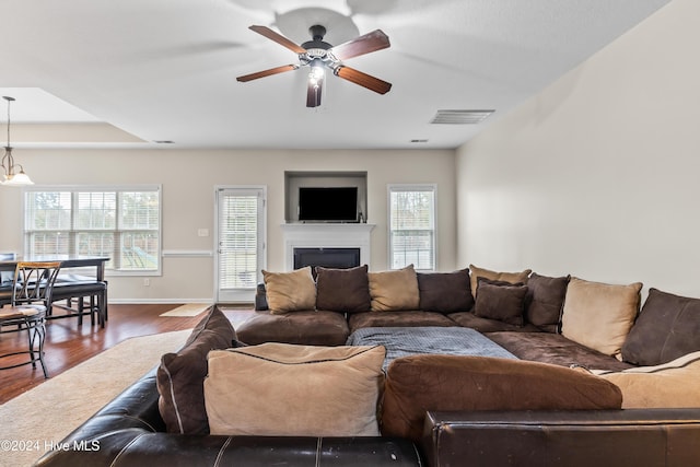 living room featuring dark hardwood / wood-style flooring and ceiling fan with notable chandelier