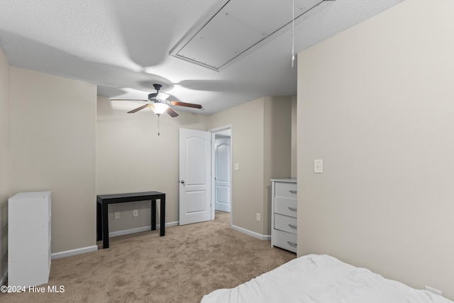 carpeted bedroom featuring ceiling fan and a textured ceiling