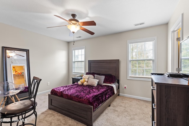 carpeted bedroom with ceiling fan and multiple windows