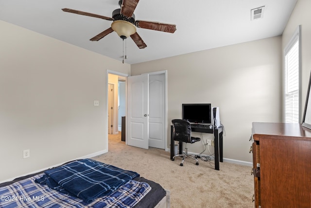 carpeted bedroom with ceiling fan and a closet