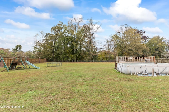 view of yard featuring a fenced in pool and a playground