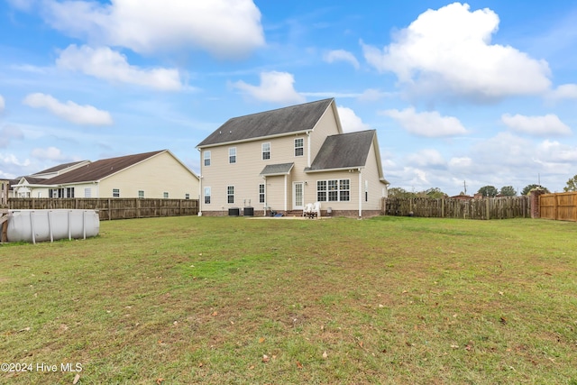 back of house featuring a yard and central AC unit