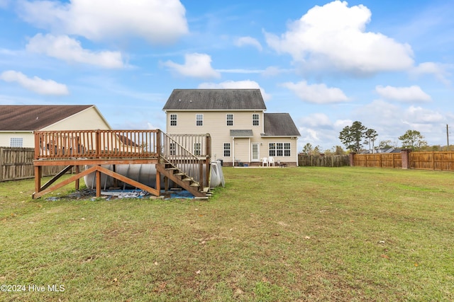 rear view of house with a deck and a yard