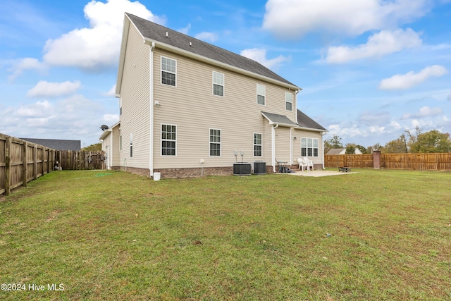 rear view of house with cooling unit, a yard, and a patio