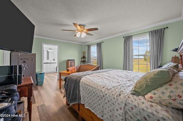 bedroom featuring ensuite bath, ceiling fan, light wood-type flooring, a textured ceiling, and ornamental molding