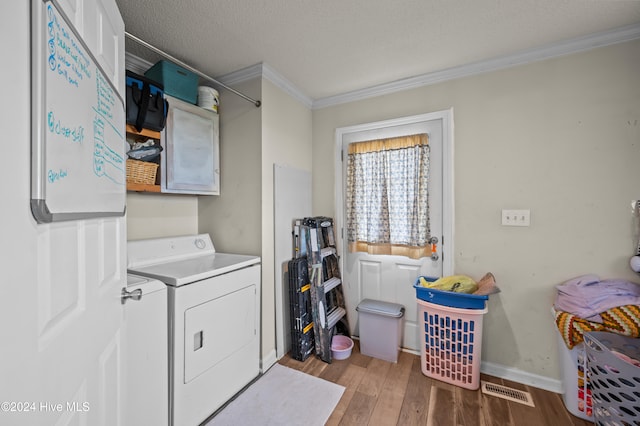 laundry room featuring independent washer and dryer, a textured ceiling, hardwood / wood-style flooring, and ornamental molding