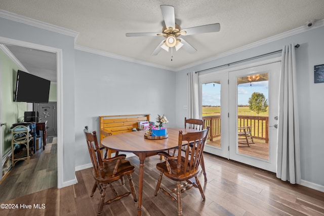 dining room with a textured ceiling, hardwood / wood-style flooring, ceiling fan, and crown molding