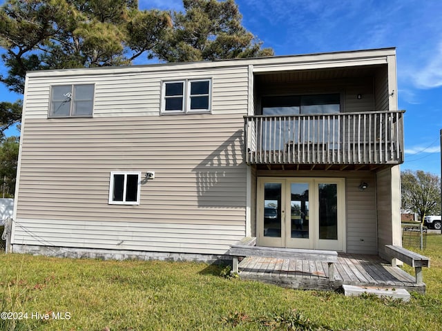 rear view of property with a balcony and a yard