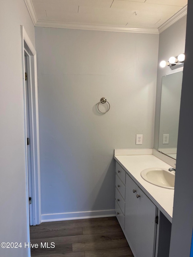 bathroom with hardwood / wood-style floors, vanity, and crown molding