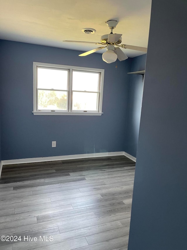 spare room featuring plenty of natural light, ceiling fan, and wood-type flooring