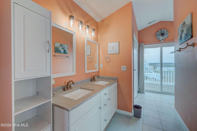 bathroom featuring tile patterned floors, vanity, and vaulted ceiling