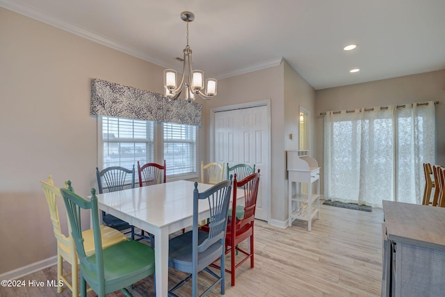 dining space with light hardwood / wood-style floors, crown molding, a wealth of natural light, and a notable chandelier