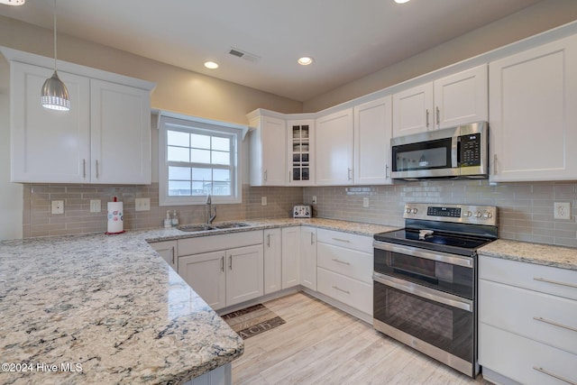 132 Reeves St, North Topsail Beach, NC 28460 - kitchen with appliances with stainless steel finishes, white cabinetry, recessed lighting, decorative light fixtures, and glass insert cabinets