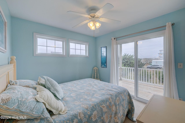 bedroom featuring access to outside, multiple windows, ceiling fan, and light colored carpet