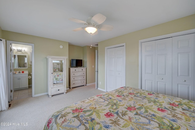 carpeted bedroom featuring connected bathroom, ceiling fan, and multiple closets