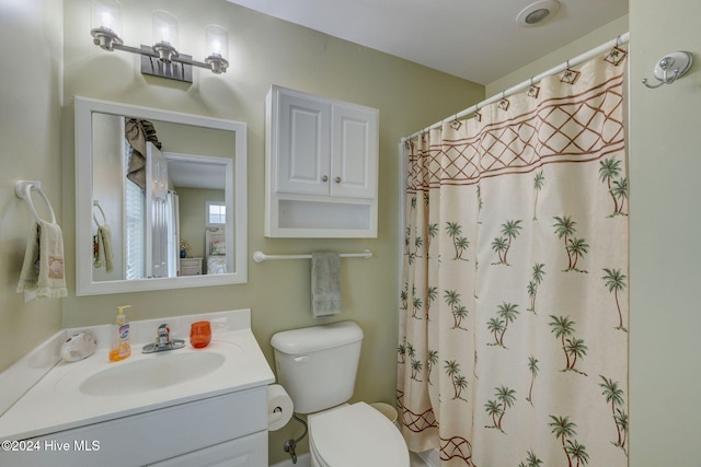 bathroom with a shower with shower curtain, vanity, and toilet