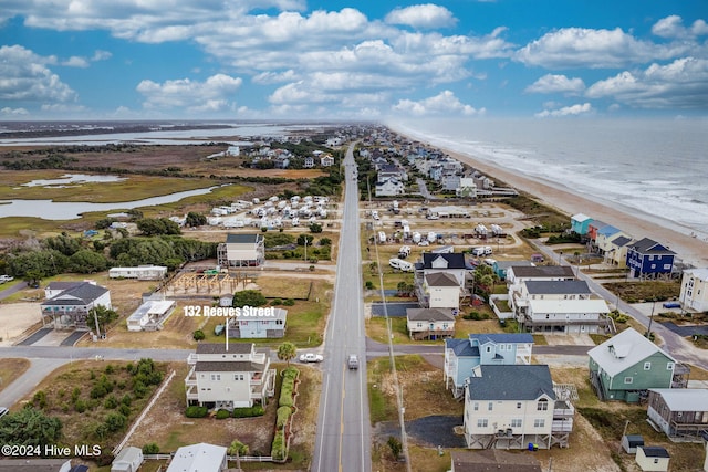 drone / aerial view featuring a water view and a beach view