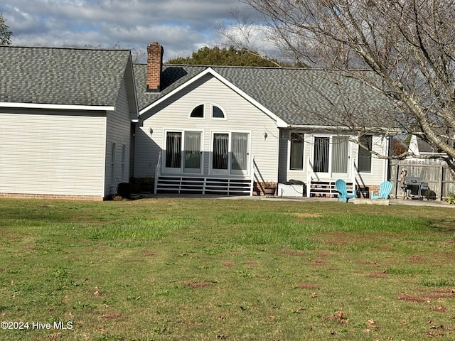 rear view of property with a lawn