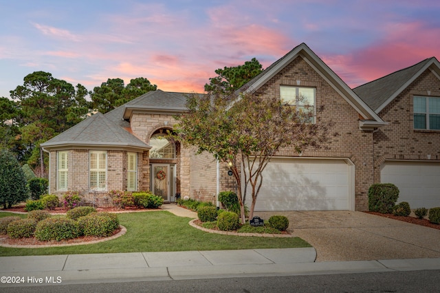 view of front of home featuring a garage and a lawn