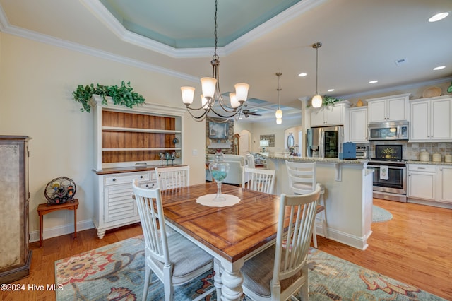 dining space with a chandelier, light hardwood / wood-style floors, and ornamental molding