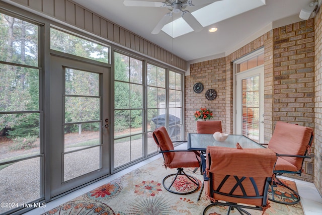 dining area with ceiling fan and brick wall