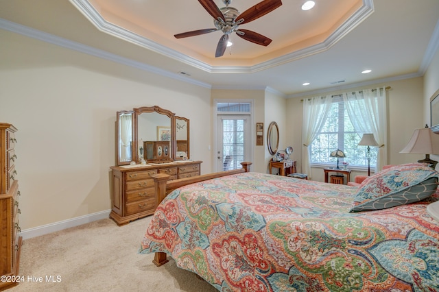 bedroom featuring a tray ceiling, crown molding, ceiling fan, and light carpet