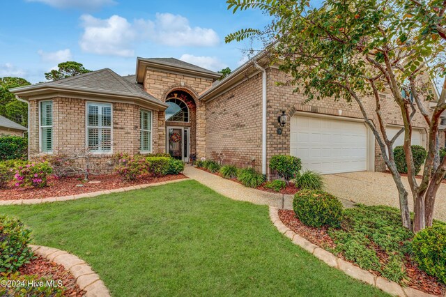 view of front of house with a garage and a front lawn