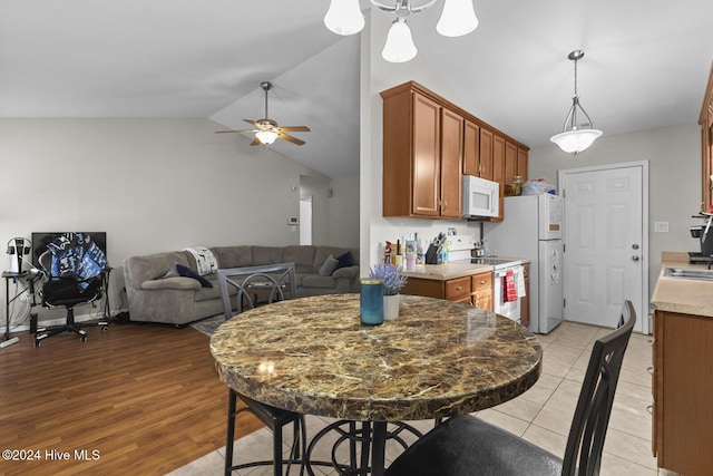 kitchen featuring lofted ceiling, ceiling fan, white appliances, and light wood-type flooring