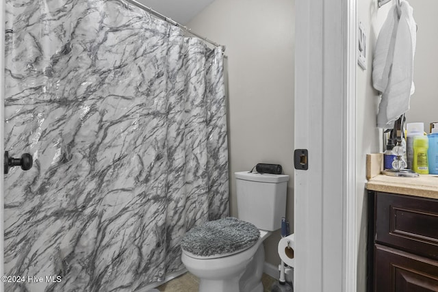 bathroom with walk in shower, vanity, and toilet