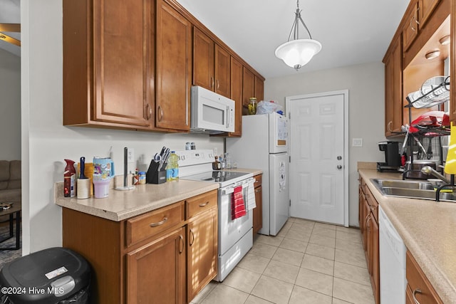 kitchen with sink, light tile patterned flooring, pendant lighting, and white appliances