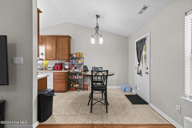 kitchen featuring dishwasher, an inviting chandelier, vaulted ceiling, light tile patterned floors, and decorative light fixtures