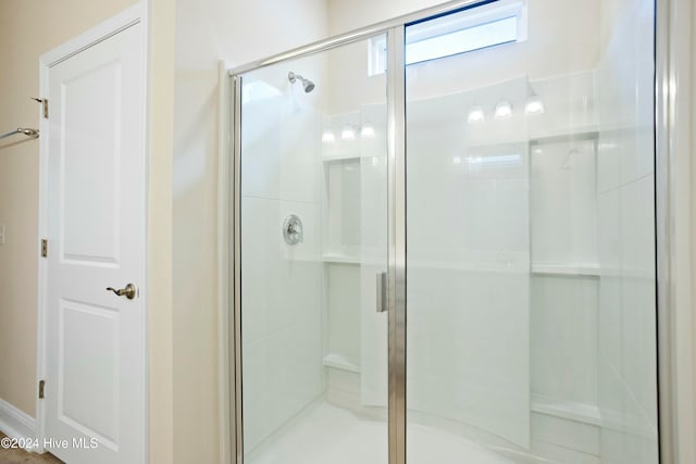 bathroom featuring a shower with shower door