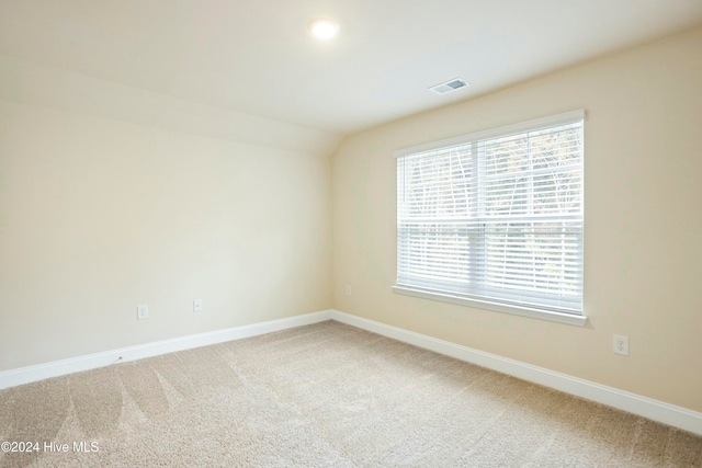 unfurnished room with carpet flooring and lofted ceiling