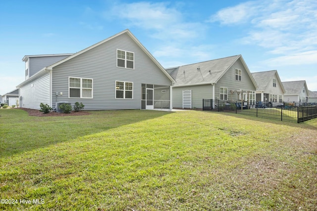 back of property with a sunroom, cooling unit, and a lawn