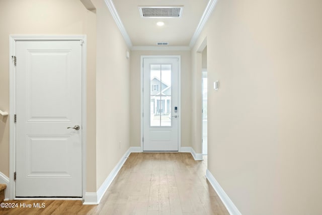 doorway featuring crown molding and light hardwood / wood-style flooring