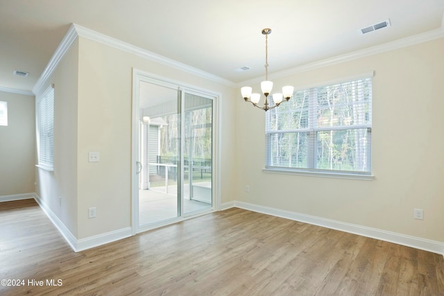 unfurnished dining area with light hardwood / wood-style floors, crown molding, and a chandelier