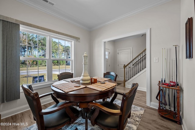 dining area featuring wood-type flooring and ornamental molding