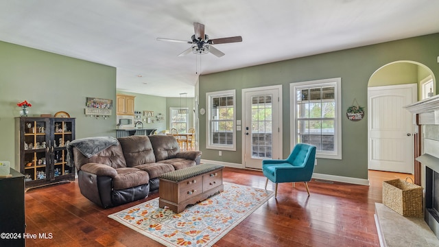 living room with ceiling fan, a fireplace, and wood-type flooring