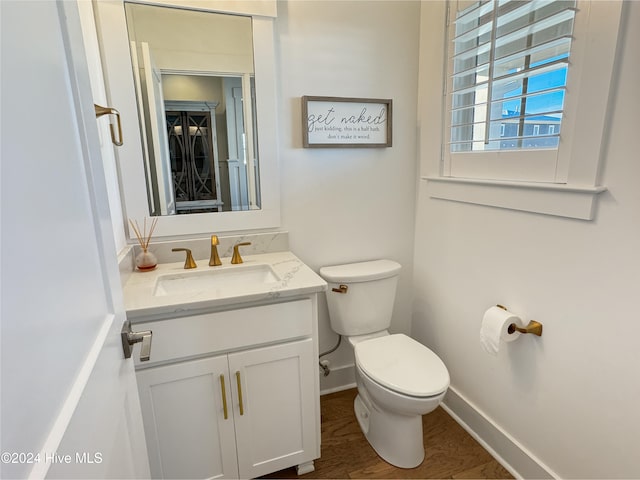 bathroom with hardwood / wood-style floors, vanity, and toilet