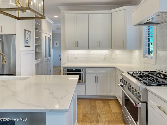 kitchen with custom exhaust hood, light wood-type flooring, white cabinetry, and stainless steel appliances